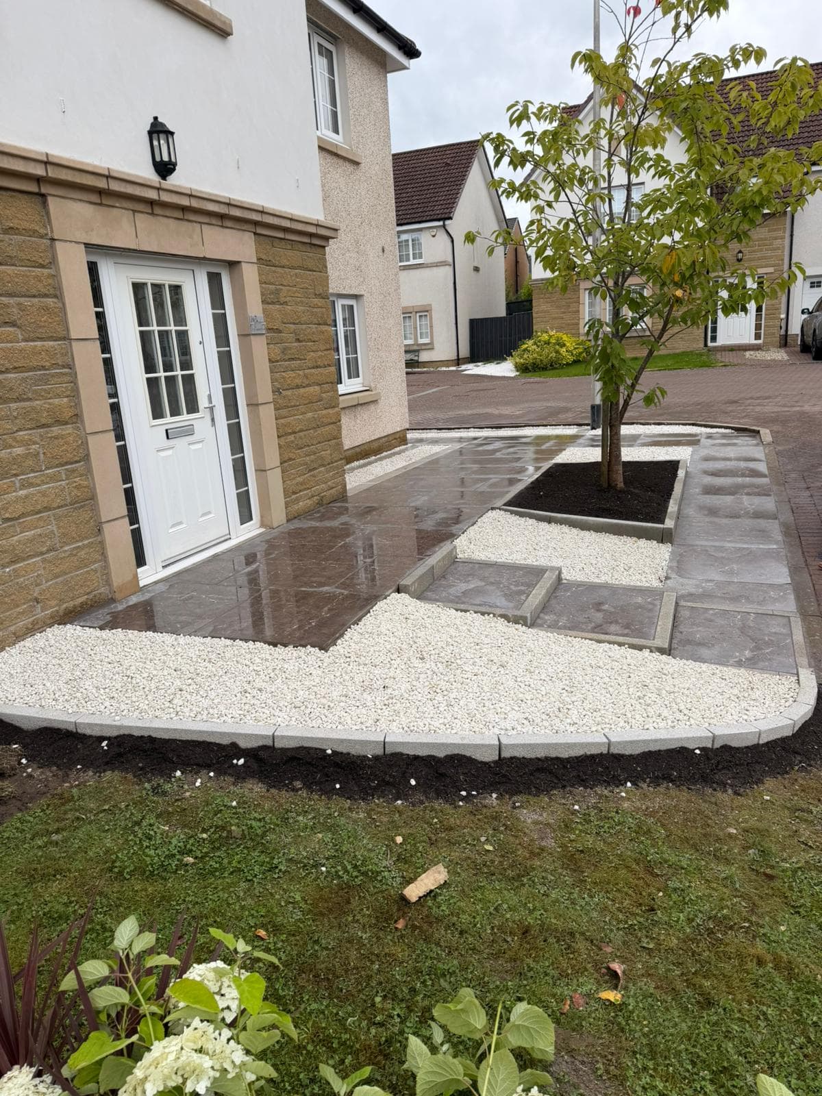 Well-kept front garden with a clean granite-edged bed and gravel finish after a maintenance visit