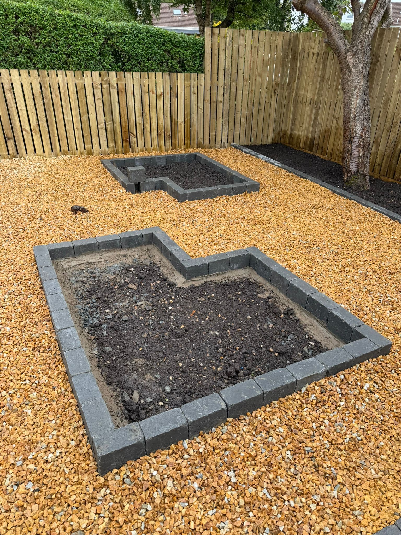 Raised block-edged planting beds set in gold gravel at a property in Old Kilpatrick