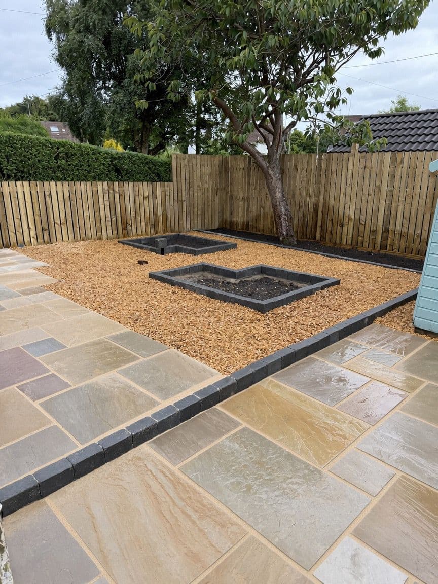 Sandstone patio, gold gravel and raised planting beds in a finished Bearsden garden