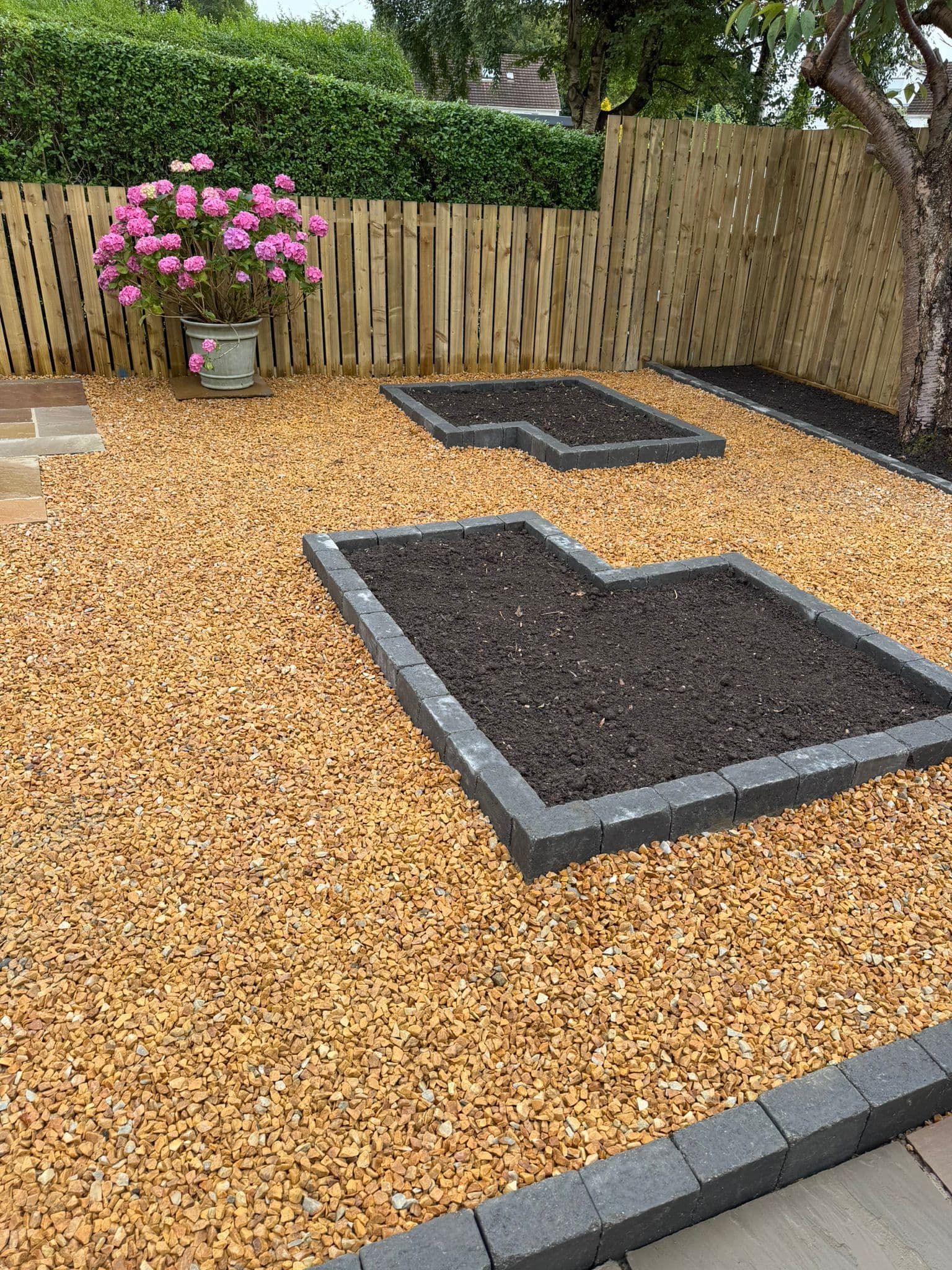 Raised planting bed with a potted hydrangea at a Langbank property overlooking the Clyde